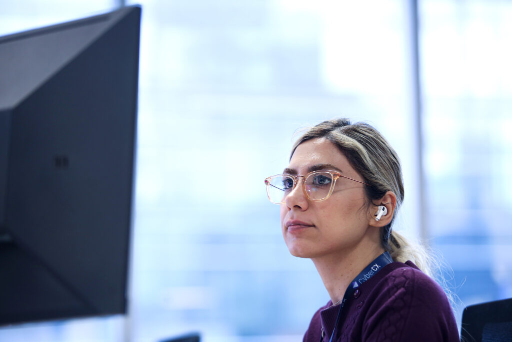 Cyber security professional in office looking at computer screen
