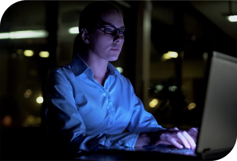 Cyber security professional in an office working on a laptop